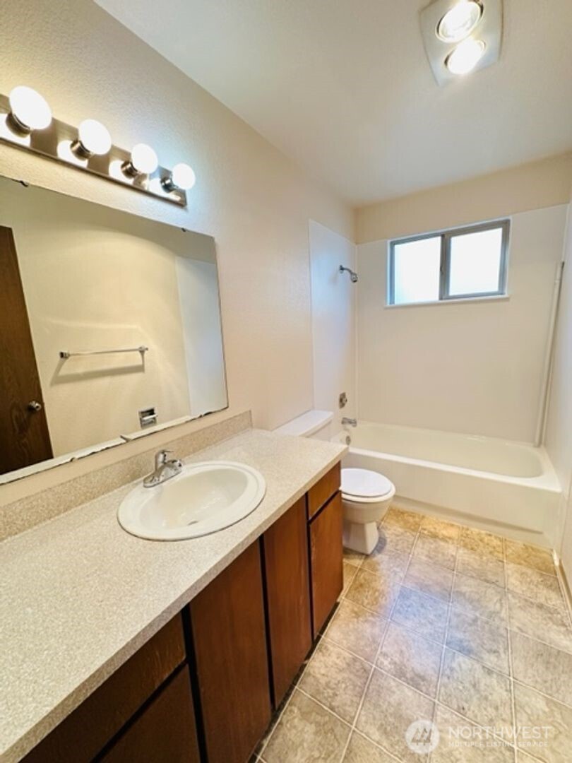 5631 Hwy Place, Unit 8 Everett, WA 98203 - Photo 10 of 11 a bathroom with a granite countertop sink a toilet and mirror