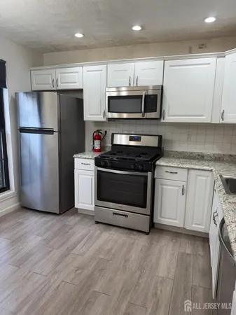 a kitchen with stainless steel appliances a refrigerator sink and microwave