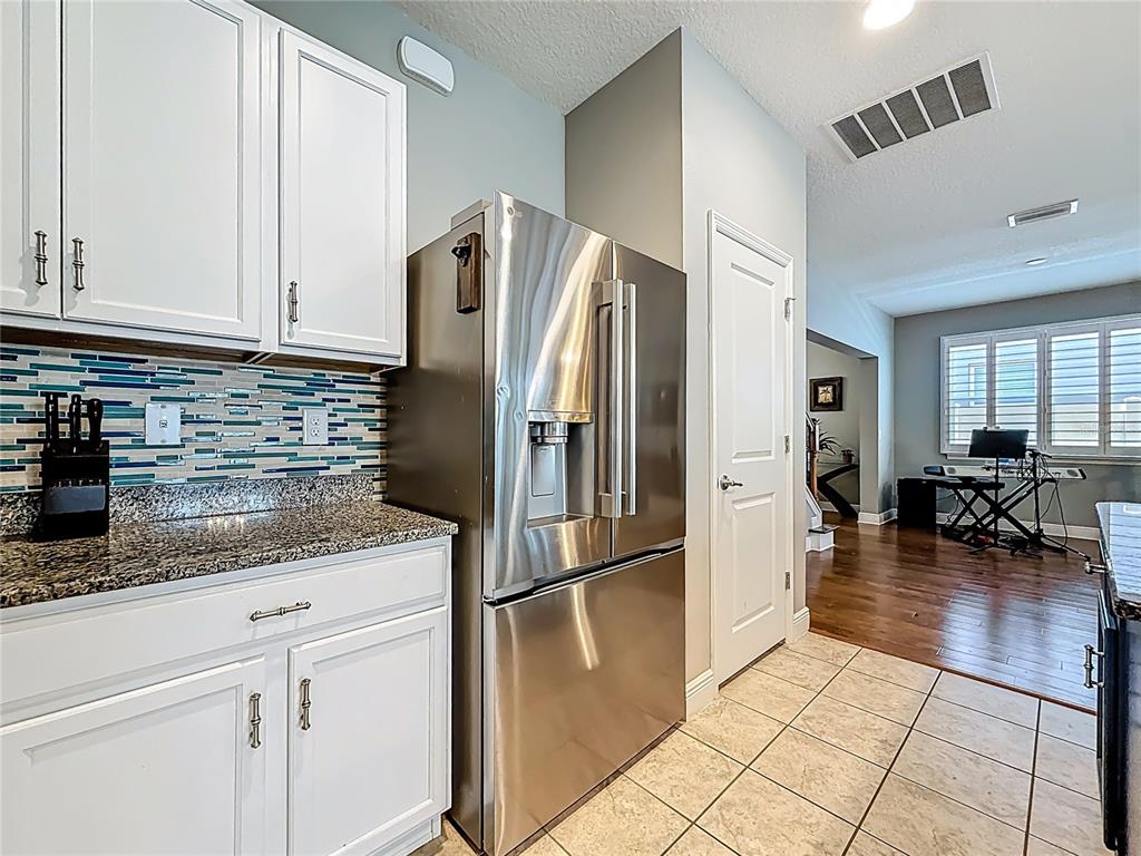 10193 Grand Oak Circle Madeira Beach, FL 33708 - Photo 18 of 67 a kitchen with granite countertop a refrigerator and a sink
