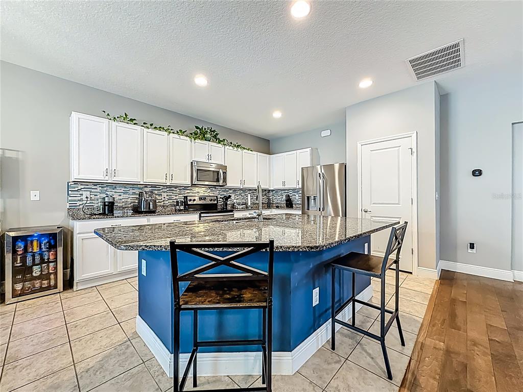 10193 Grand Oak Circle Madeira Beach, FL 33708 - Photo 22 of 67 a kitchen with stainless steel appliances granite countertop a stove a sink a refrigerator and cabinets
