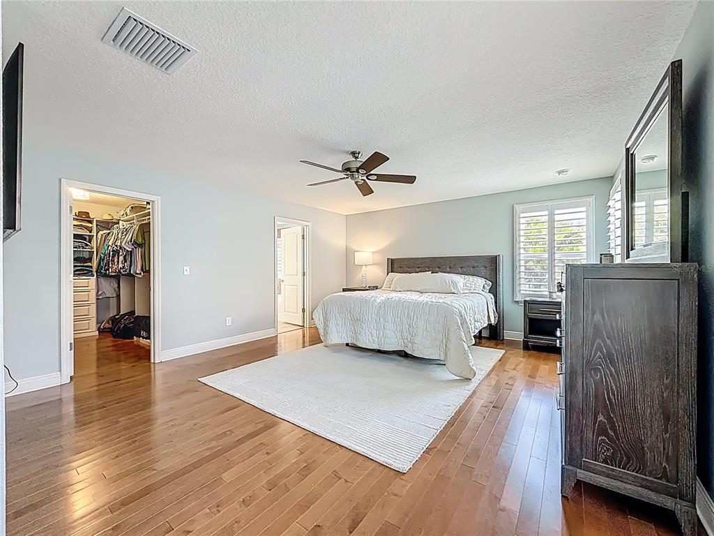 10193 Grand Oak Circle Madeira Beach, FL 33708 - Photo 25 of 67 a bedroom with a bed and wooden floor