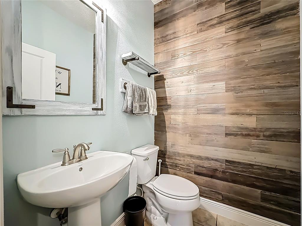 10193 Grand Oak Circle Madeira Beach, FL 33708 - Photo 26 of 67 a bathroom with a sink a toilet and mirror