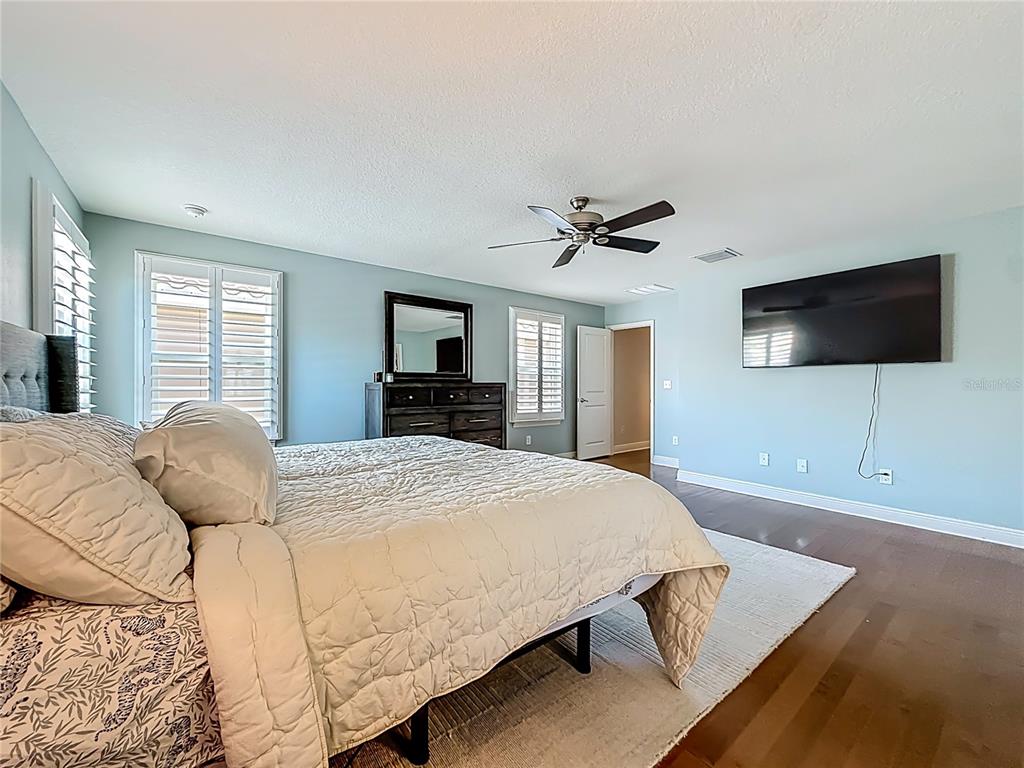 10193 Grand Oak Circle Madeira Beach, FL 33708 - Photo 28 of 67 a bedroom with a bed and a flat screen tv