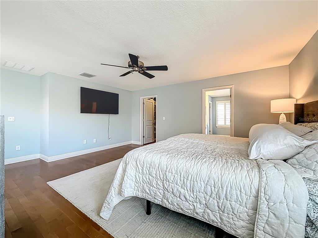 10193 Grand Oak Circle Madeira Beach, FL 33708 - Photo 29 of 67 a bedroom with a bed and a flat screen tv