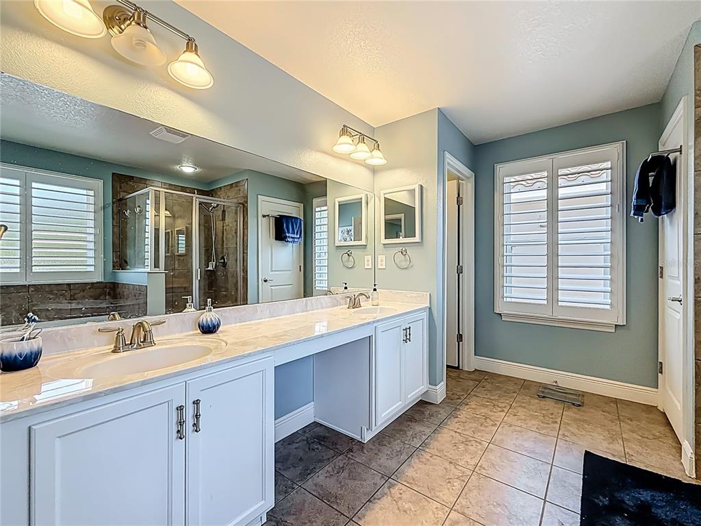 10193 Grand Oak Circle Madeira Beach, FL 33708 - Photo 33 of 67 a spacious bathroom with a sink mirror and a bath tub