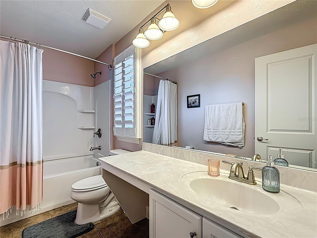 10193 Grand Oak Circle Madeira Beach, FL 33708 - Photo 43 of 67 a bathroom with a granite countertop toilet sink and a mirror