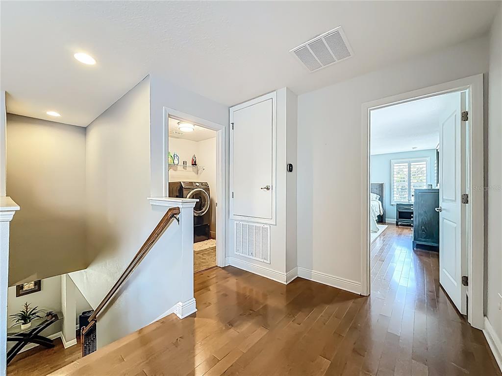 10193 Grand Oak Circle Madeira Beach, FL 33708 - Photo 48 of 67 a view of a hallway with wooden floor and stairs