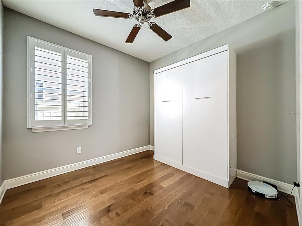 10193 Grand Oak Circle Madeira Beach, FL 33708 - Photo 50 of 67 a view of an empty room with wooden floor and a window
