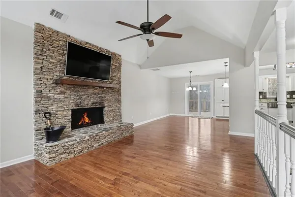 a view of empty room with wooden floor and a fireplace