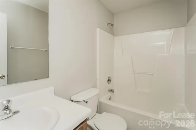a white toilet sitting next to a bath tub