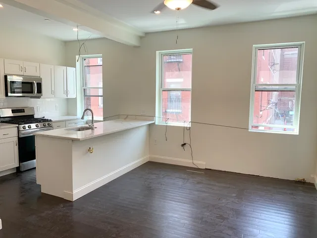 a kitchen with stainless steel appliances granite countertop a sink a stove a microwave a counter space and cabinets