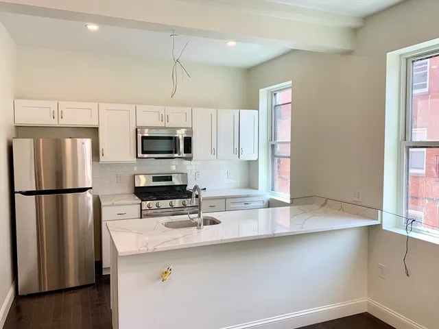 a kitchen with stainless steel appliances a microwave a sink and a refrigerator