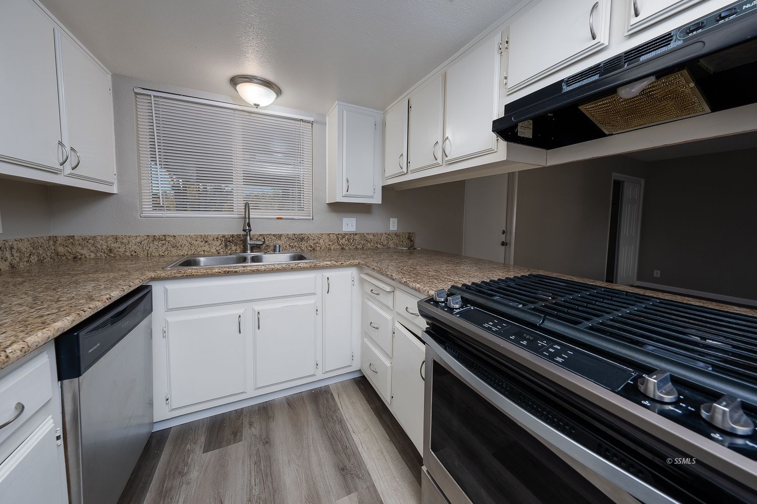 609 West Joyner Avenue Ridgecrest, CA 93555 - Photo 5 of 29 a kitchen with granite countertop stainless steel appliances and white cabinets