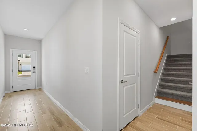 a view of a hallway with wooden floor and stairs