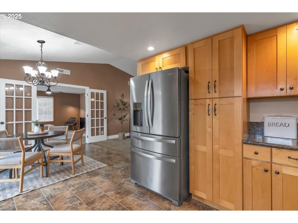 1393 Southwest Alexander Drive Dallas, OR 97338 - Photo 21 of 47 a kitchen with stainless steel appliances kitchen island granite countertop a refrigerator a stove a dining table and chairs with wooden floor