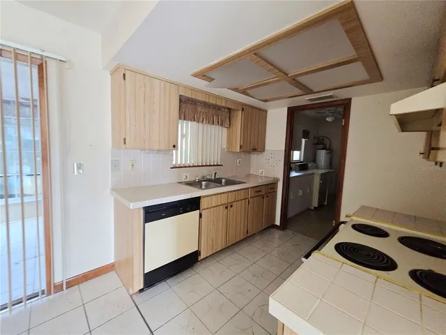 a kitchen with granite countertop a stove a sink and a refrigerator