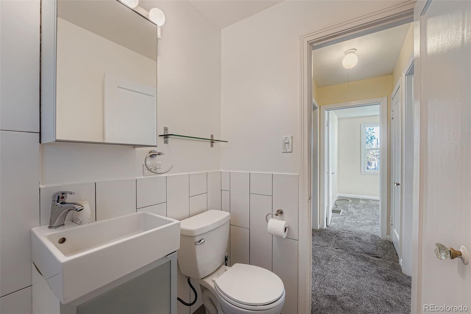 3630 Fillmore Street Denver, CO 80205 - Photo 14 of 50 a white toilet sitting next to a bathroom sink