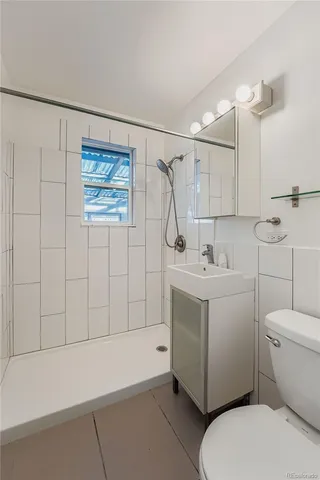 a bathroom with a sink a toilet and shower