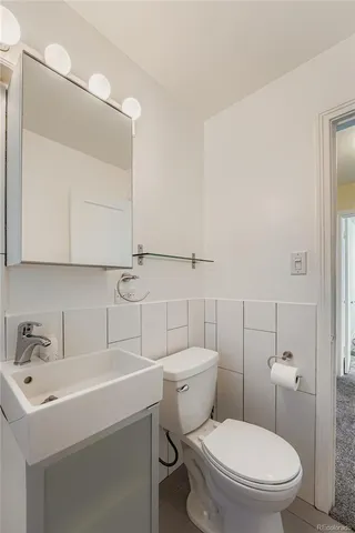 a bathroom with a sink a toilet and mirror
