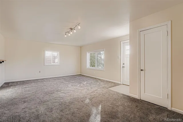 an empty room with windows and closet