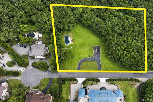 an aerial view of a swimming pool with a yard