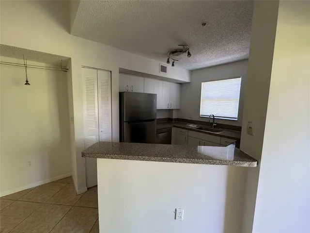 a kitchen with a refrigerator and microwave