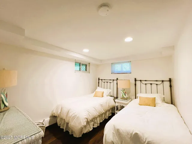 a spacious bedroom with two beds and painting on the wall