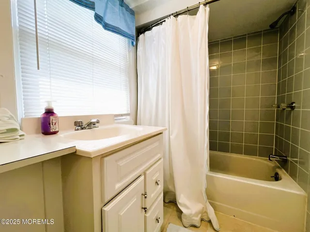 a bathroom with a tub sink and mirror