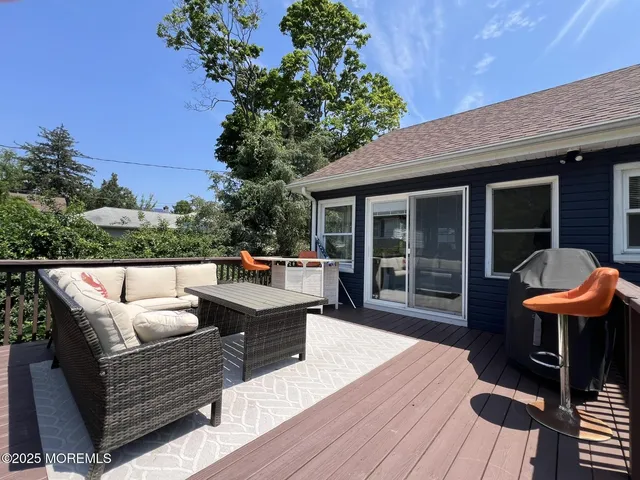 a balcony with wooden floor table and chairs