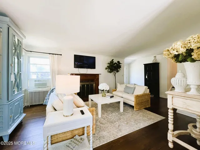 a living room with furniture a fireplace and a flat screen tv