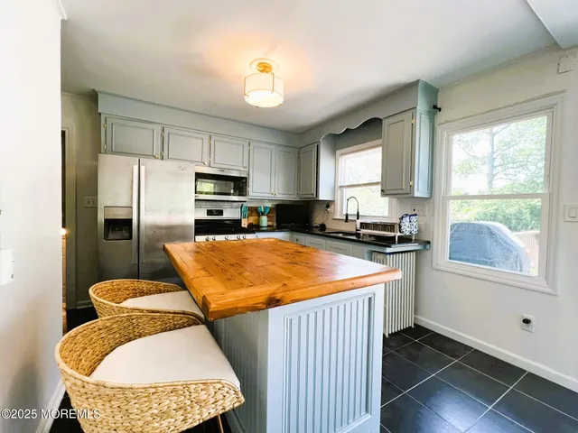 a kitchen with stainless steel appliances granite countertop sink stove refrigerator and window
