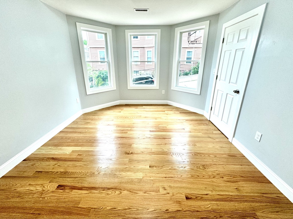 190 Hillside Street, Unit 1 Boston, MA 02120 - Photo 14 of 27 a view of an empty room with wooden floor and a window