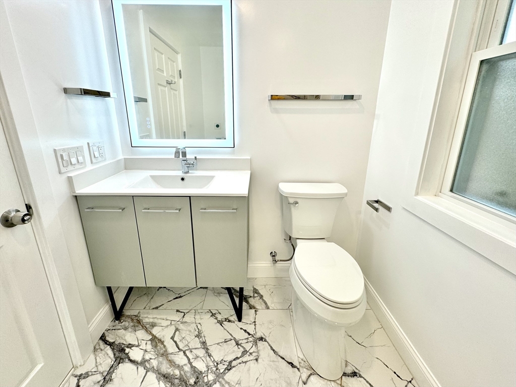 190 Hillside Street, Unit 1 Boston, MA 02120 - Photo 5 of 27 a bathroom with a toilet sink and mirror