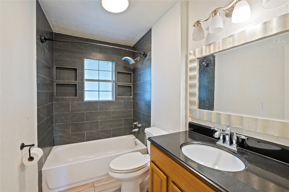 2308 Grape Lane Pasadena, TX 77502 - Photo 18 of 19 a bathroom with a granite countertop sink toilet mirror and bathtub