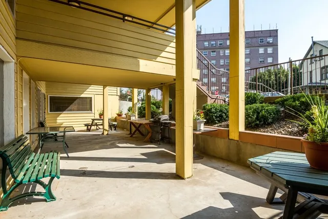 a view of a patio with a table and chairs and potted plants