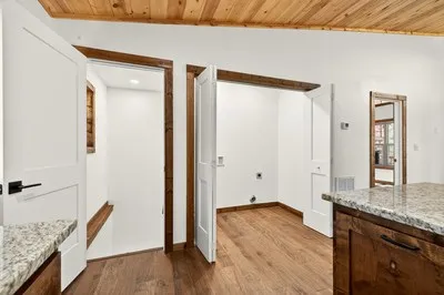 a view of bathroom with granite countertop tub and wooden floor