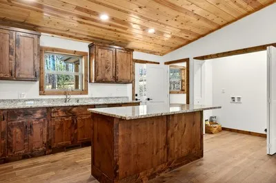 a kitchen with granite countertop a sink a counter space and wooden floor