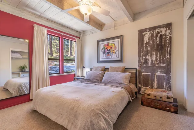 a bedroom with a bed a window and glass walk in closet