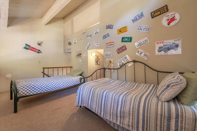 a bedroom with bed and a painting on the wall