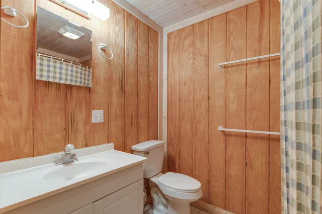 a bathroom with a sink a toilet and shower curtain