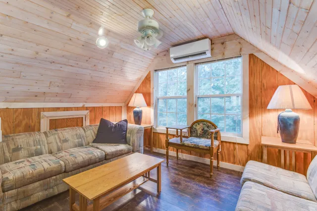 a living room with furniture floor to ceiling window and wooden floor