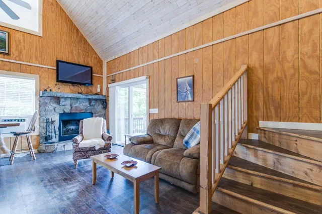 a living room with furniture a fireplace and a wooden floor