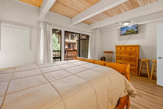 a bedroom with a bed a dresser and painting on the wall