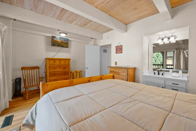 a bedroom with a bed and dresser with mirror