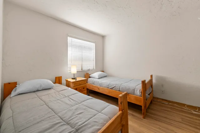 a bedroom with two beds and wooden furniture