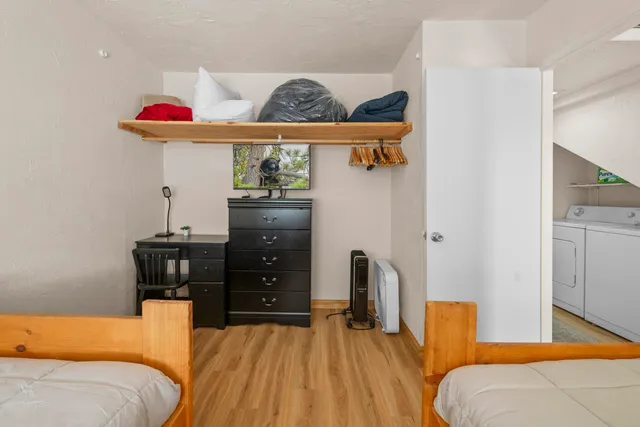 a bedroom with a bed and wooden floor