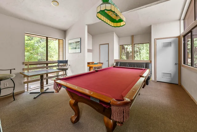 a room with pool table and windows
