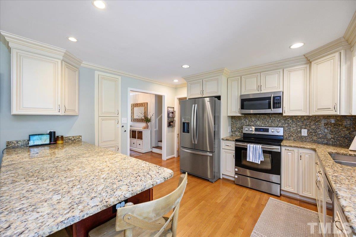 7509 Harps Mill Road Raleigh, NC 27615 - Photo 15 of 31 a kitchen with stainless steel appliances granite countertop a sink refrigerator and microwave