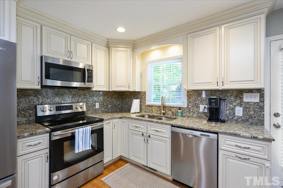 7509 Harps Mill Road Raleigh, NC 27615 - Photo 18 of 31 a kitchen with granite countertop a stove top oven microwave and cabinets