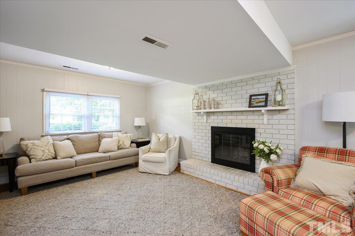7509 Harps Mill Road Raleigh, NC 27615 - Photo 28 of 31 a living room with furniture and a fireplace